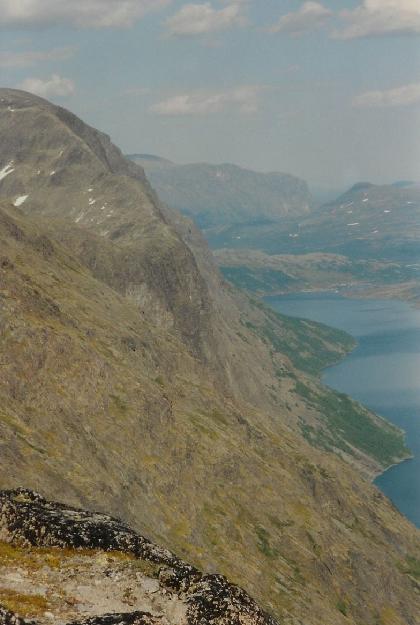 Vue tilbage mod Besseggen, verst tv. Vandreruten ses som en lys stribe. Th. Gjende med Gjendesheim i baggrunden.